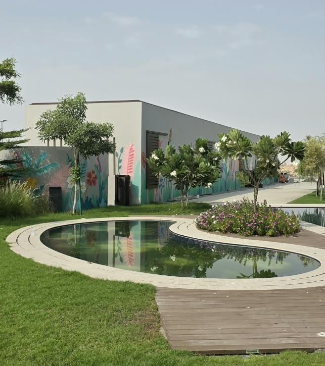 Curved pond water feature with lawn and timber deck in a landscaped courtyard